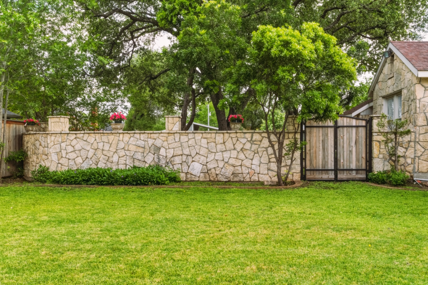 Limestone garden wall and gate bordering the backyard at Casa Thorman