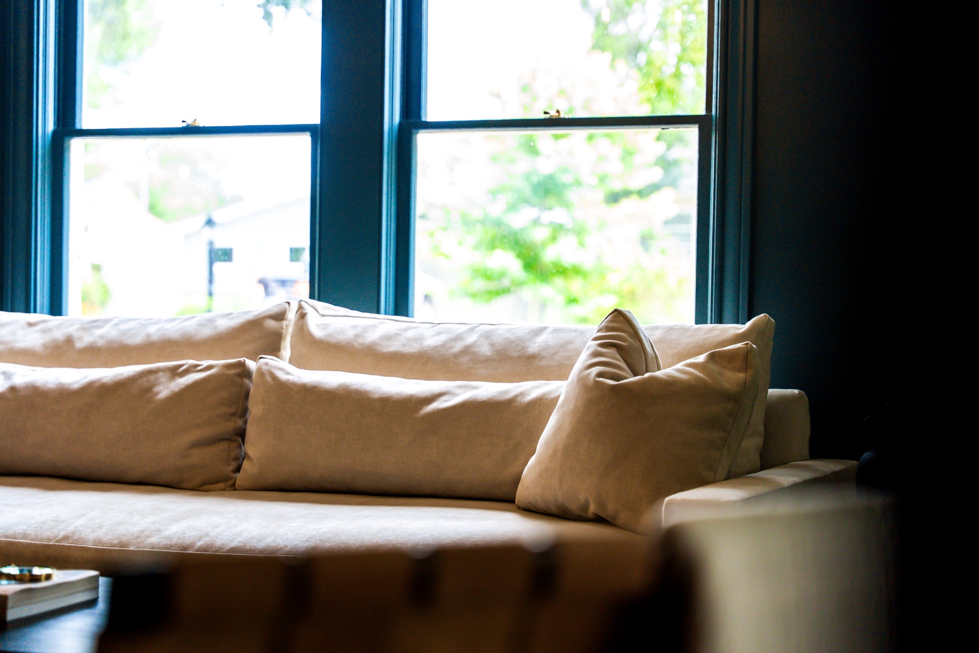 Linen sofa beneath navy-trimmed windows in the living room at Casa Thorman