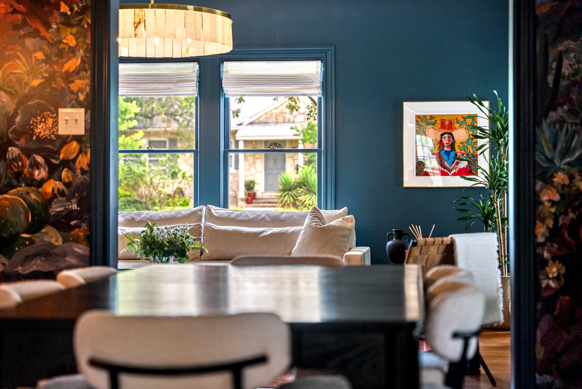 View from the dining table through the doorway into the navy living room at Casa Thorman