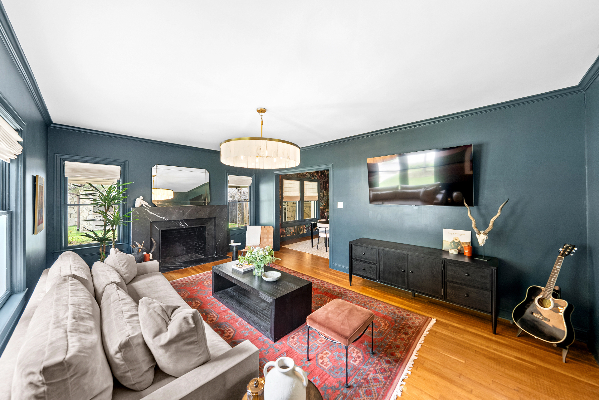 Wide view of the living room with black marble fireplace and capiz chandelier at Casa Thorman