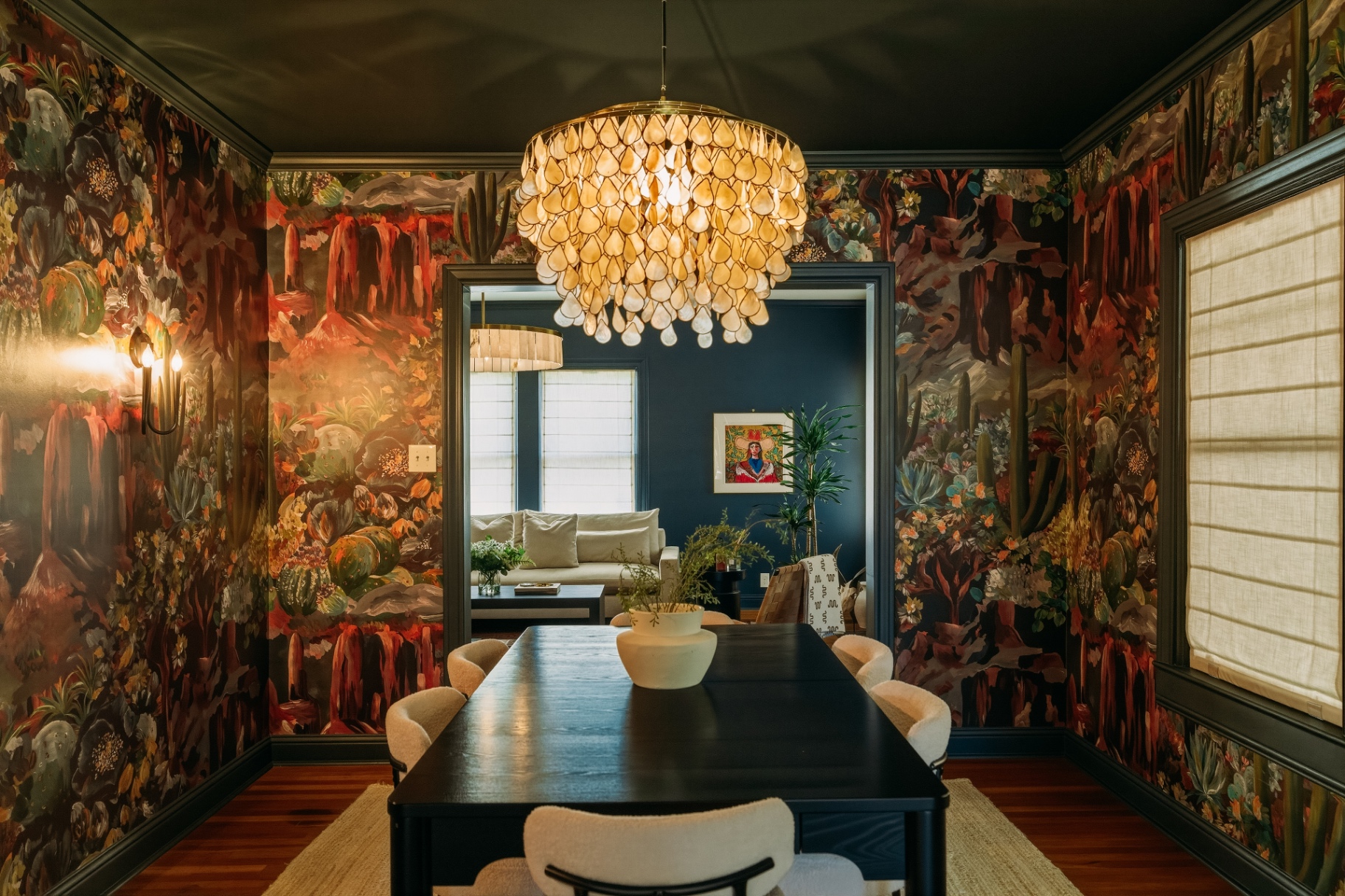 Dining room with capiz chandelier, black table, and desert mural at Casa Thorman