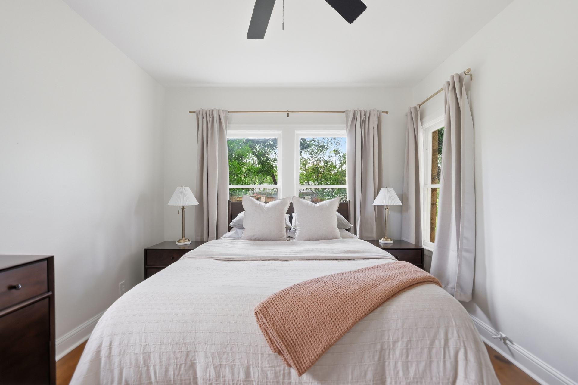Bedroom with soft neutral bedding and reading chair at Casa Thorman